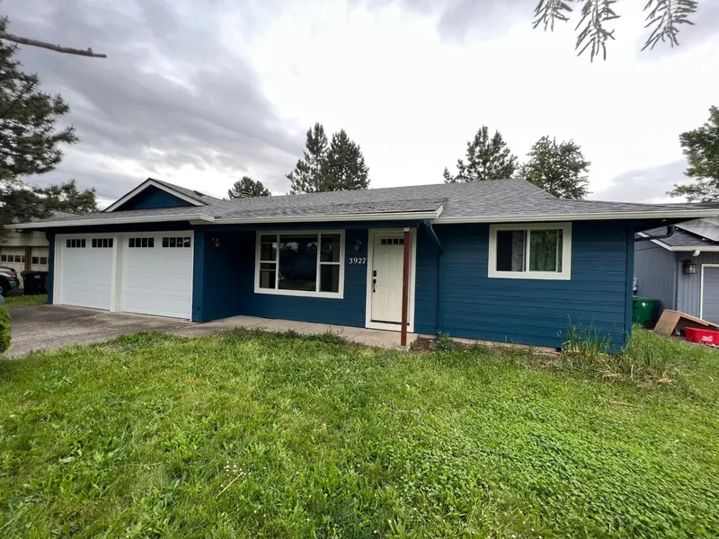 Single-story home with deep navy siding, white trim and a two-car garage