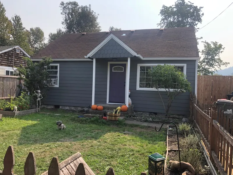 Gray home with a purple front door and a small front yard
