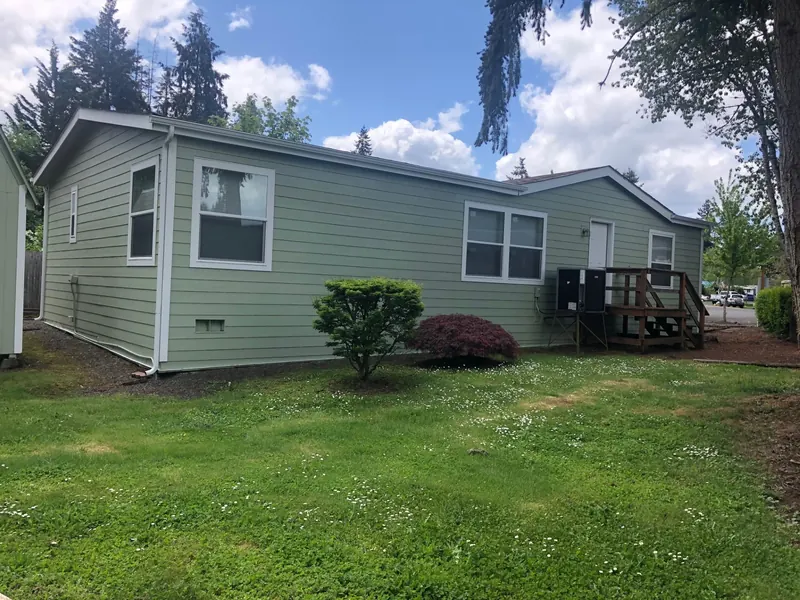 Sage green manufactured home with new lap siding and white trim