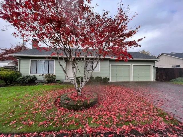Pale green ranch home with a red maple in the front yard
