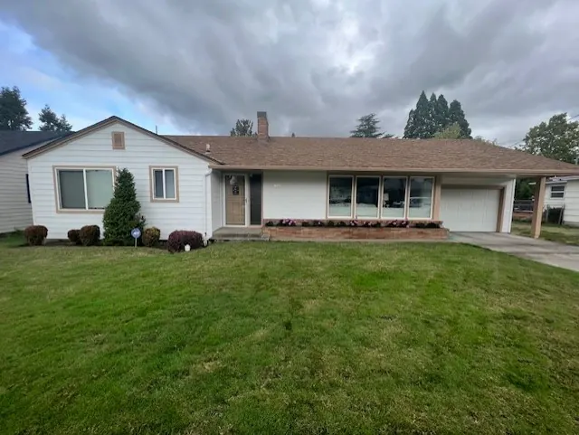 Cream and white ranch-style home with a deep front lawn