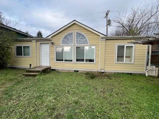 Yellow single-story home with an arched window