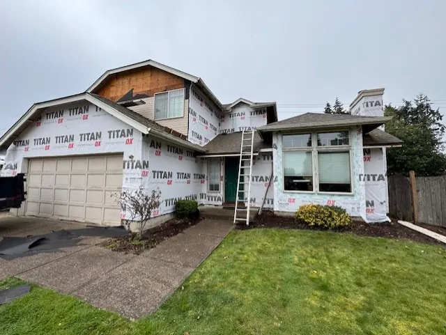 Two-story home wrapped in house wrap during siding installation