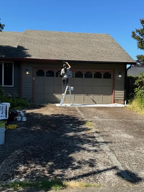 Painter at work on a garage exterior